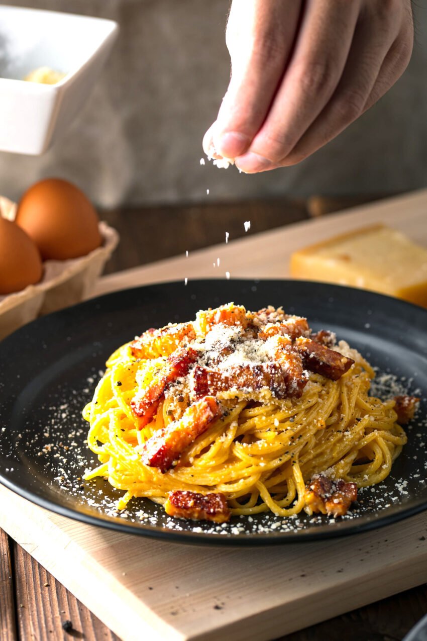 delicious pasta carbonara on black plate.